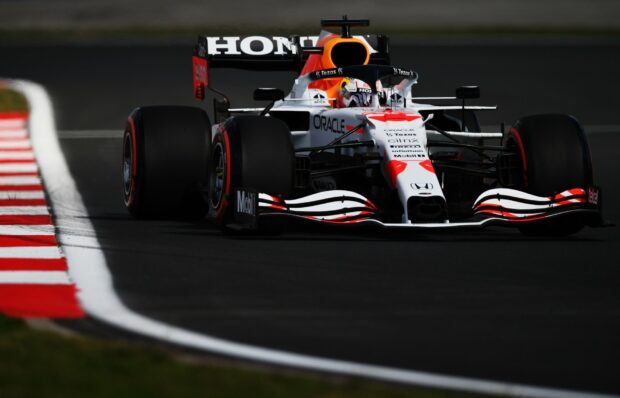 A Formula One car races along the track with red and white curbs visible, HD Desktop Wallpaper