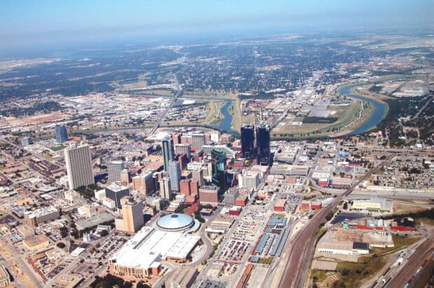 An aerial view shows the cityscape of Fort Worth with buildings and winding river, HD Desktop Wallpaper