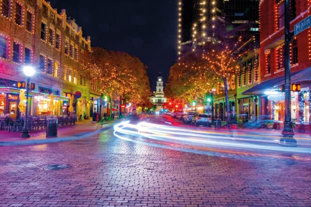 A vibrant Fort Worth city street with illuminated trees and light trails, 2K Desktop Wallpaper