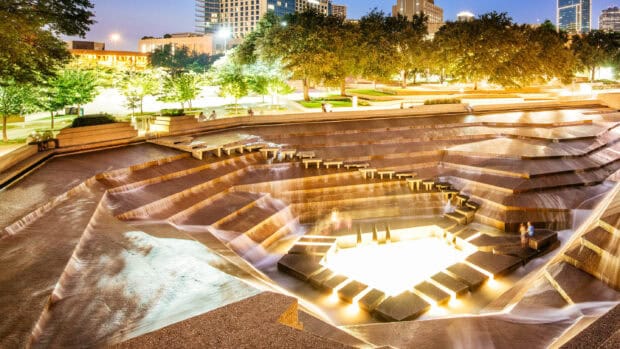 A bright illuminated tiered fountain surrounded by trees in Fort Worth featured in Fort Worth Wallpapers, 2K Desktop Wallpaper
