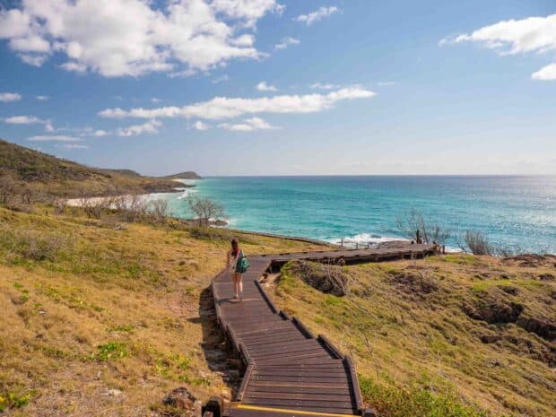 A person walking along a wooden trail beside the ocean on Fraser Island, 2K Desktop Wallpaper