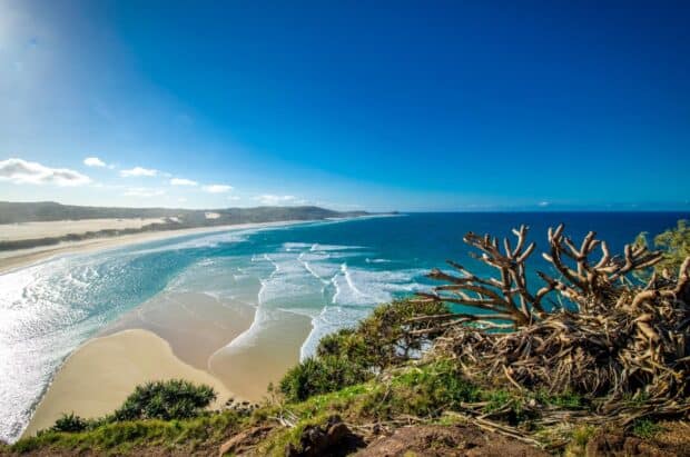 A breathtaking view of Fraser Island with sandy beaches and blue ocean waves under a clear sky, HD Desktop Wallpaper