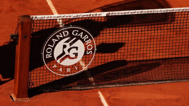 The French Open Roland Garros logo is visible on the tennis net on a clay court, HD Desktop Wallpaper