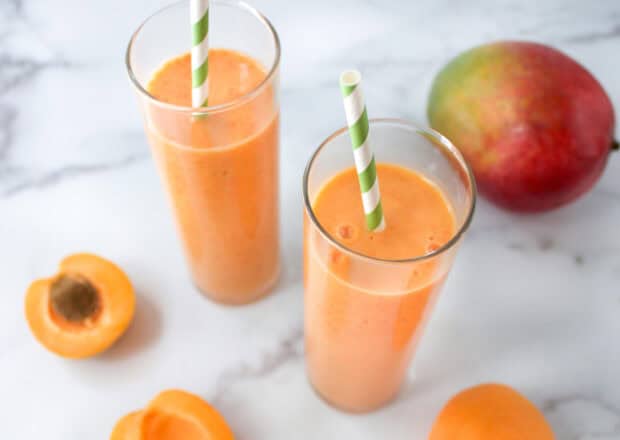 A fresh apricot drink in tall glasses with ripe apricots on a marble surface, HD Desktop Wallpaper