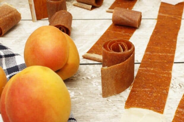 Fresh apricots and fruit leather rolls on a wooden surface, HD Desktop Wallpaper