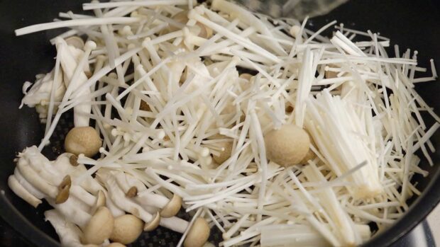 A close up of fresh enoki mushrooms and other types cooking in a pan, HD Desktop Wallpaper