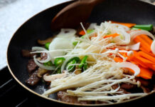 A pan with enoki mushrooms, sliced carrots, onions, and green peppers cooking together, HD Desktop Wallpaper