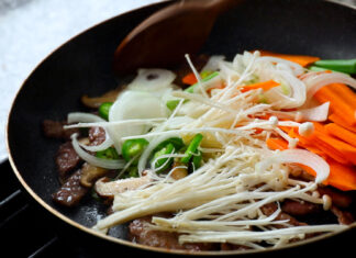 A pan with enoki mushrooms, sliced carrots, onions, and green peppers cooking together, HD Desktop Wallpaper