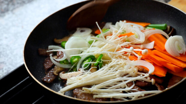 A pan with enoki mushrooms, sliced carrots, onions, and green peppers cooking together, HD Desktop Wallpaper