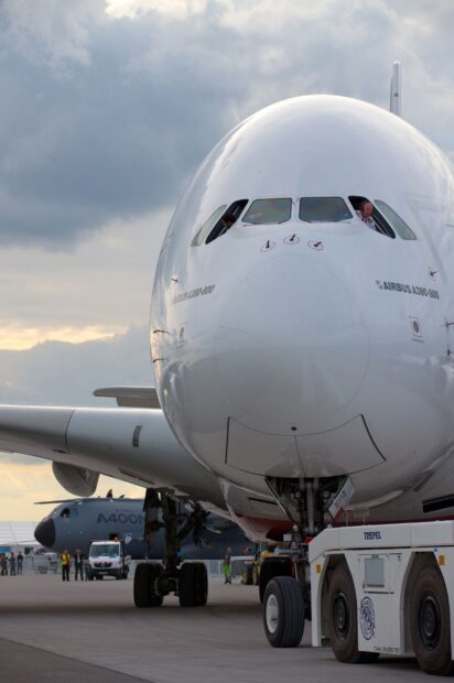 The Airbus A380 is parked on the runway with crew visible in the cockpit windows, HD Desktop Wallpaper