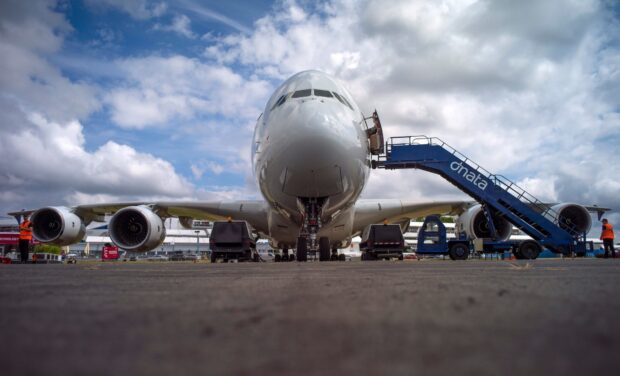 The Airbus A380 is parked on the runway with service equipment around under a cloudy sky, HD Desktop Wallpaper