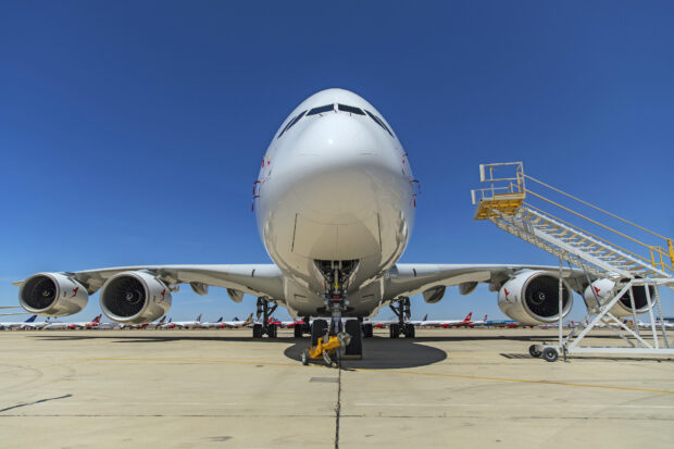 An Airbus A380 is parked on the airport runway under a clear blue sky, HD Desktop Wallpaper