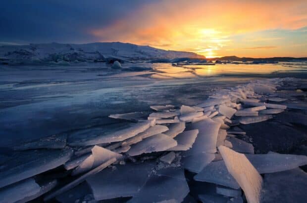 The frozen glacier is illuminated by a vibrant sunset in this natural scene, HD Desktop Wallpaper