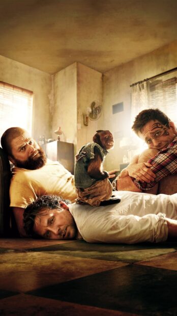 Zach Galifianakis sits with two men and a monkey in a rustic room, 2K Mobile Wallpaper