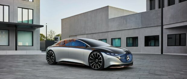 A sleek Mercedes Benz Eqs is parked in front of a modern building showing its aerodynamic profile, 2K Desktop Wallpaper