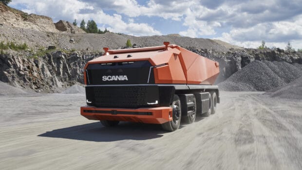A futuristic Scania truck is driving on a rocky dirt road surrounded by hills, 2K Desktop Wallpaper