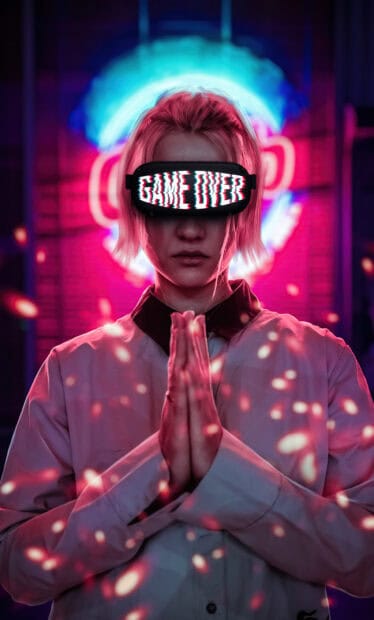 A person with game over goggles stands with hands pressed together in a neon glow, HD Phone Wallpaper