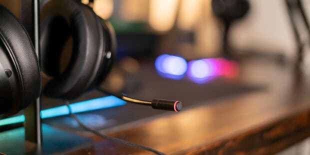 A close up of a gaming microphone with a black headset on a wooden desk, 2K Desktop Wallpaper