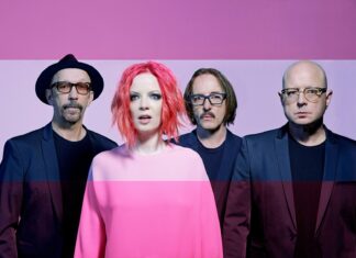 Garbage band members stand against a pink background wearing dark blazers and colorful outfits, HD Desktop Wallpaper