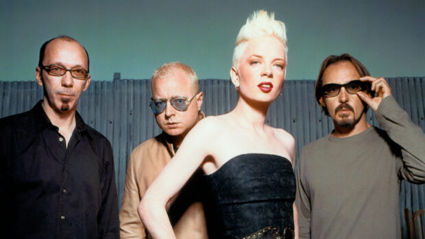 The Garbage band members stand confidently in front of a fence under a green sky, HD Desktop Wallpaper