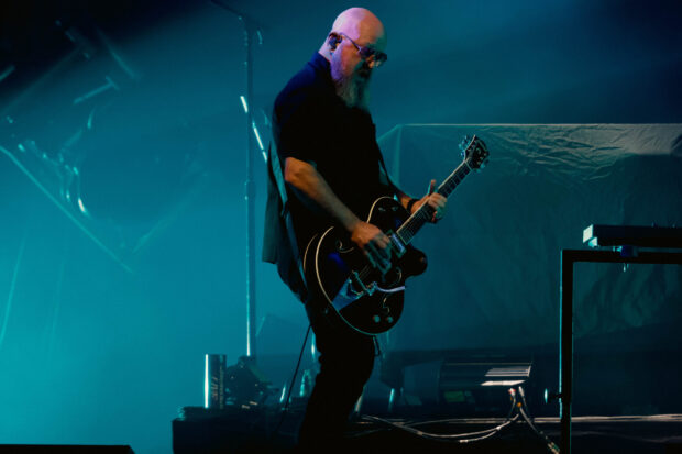 A guitarist from the Garbage band plays an electric guitar during a live concert performance, 2K Desktop Wallpaper