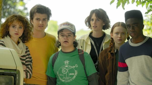 Gaten Matarazzo and friends are standing together outdoors with concerned expressions, HD Desktop Wallpaper