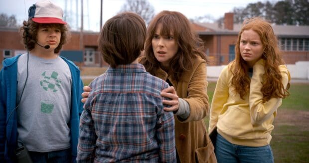 A tense scene with Gaten Matarazzo and others outside a building, 2K Desktop Wallpaper