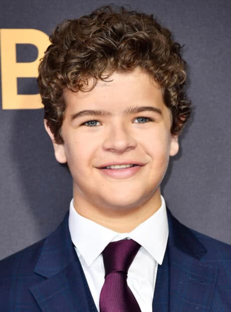 Gaten Matarazzo is wearing a suit and tie with a smile at an event, HD Desktop Wallpaper