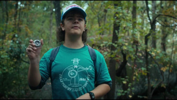 Gaten Matarazzo is holding a compass while standing in a forest during daylight, HD Desktop Wallpaper