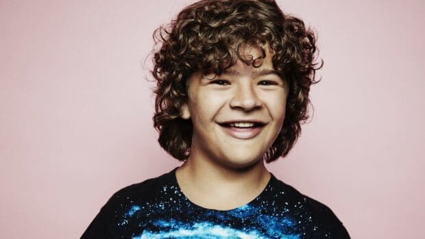 Gaten Matarazzo smiles happily wearing a starry shirt on a pink background, HD Desktop Wallpaper