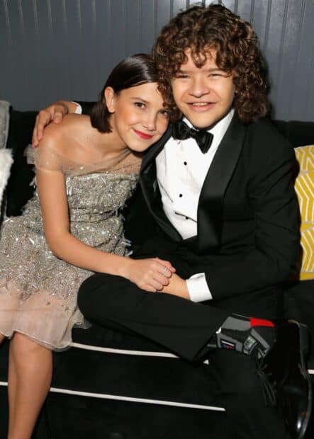 Gaten Matarazzo sits beside a smiling friend dressed in an elegant dress and tuxedo, HD Desktop Wallpaper