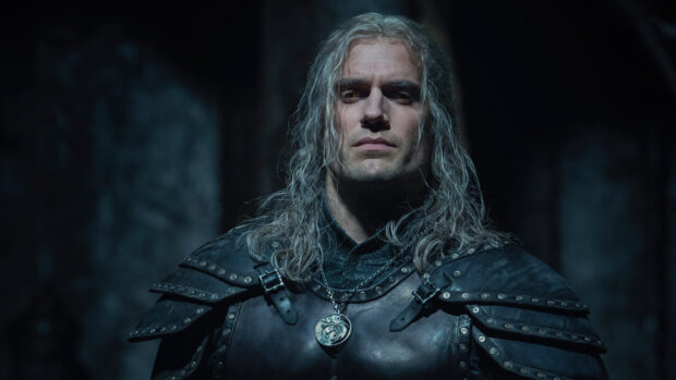 Geralt of Rivia stands in dark armor with a wolf medallion in The Witcher Tv Series, 4K Desktop Wallpaper