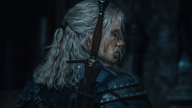 Geralt of Rivia holds his sword ready in a dark setting from The Witcher Tv Series, 2K Desktop Wallpaper