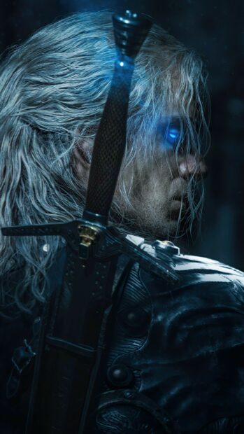 A close up view of Geralt with glowing eyes holding a sword in The Witcher Tv Series Wallpapers, 2K Phone Wallpaper