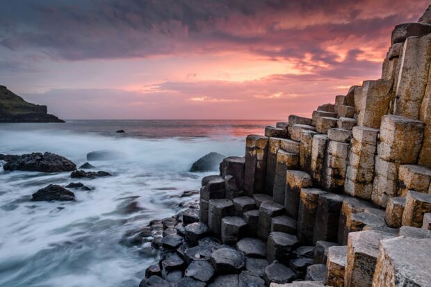 The sun sets behind the unique stones at Giants Causeway along the coast, HD Desktop Wallpaper