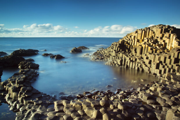Unique Giants Causeway rock formations along the sea coast on a clear day, 2K Desktop Wallpaper