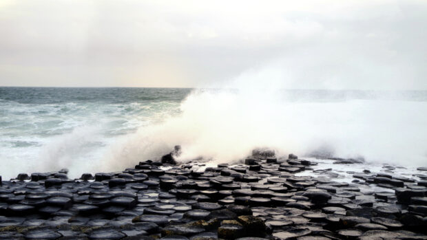 Waves crashing over Giants Causeway natural hexagonal rock formation on the coast, 4K Desktop Wallpaper