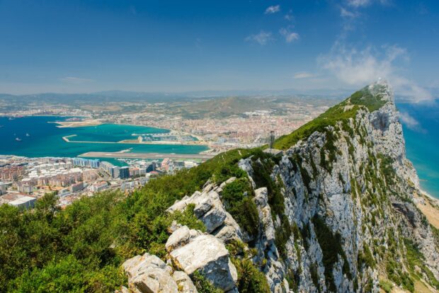 The Gibraltar Rock overlooks the town and harbor with a clear blue sky in the background, 2K Desktop Wallpaper
