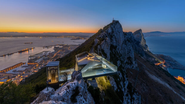 The Gibraltar rock is illuminated with city lights at sunset overlooking the sea, HD Desktop Wallpaper
