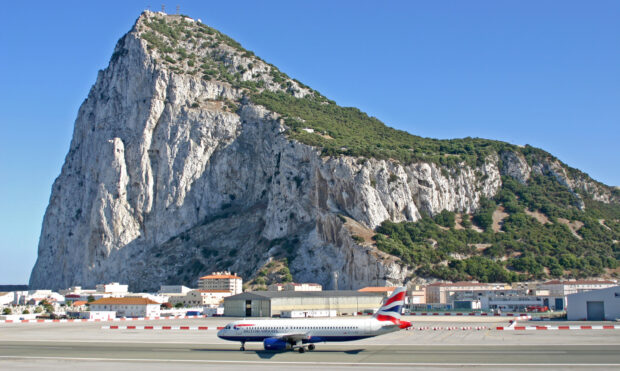 A British Airways airplane is taxiing near the Gibraltar rock under a clear blue sky, HD Desktop Wallpaper