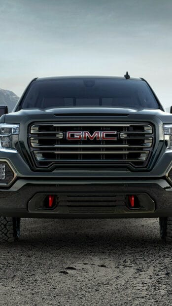 The image shows the front view of a GMC Sierra with detailed grille and headlights, HD Mobile Wallpaper