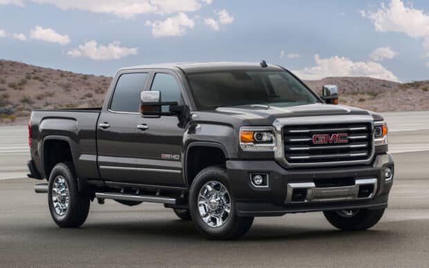 A black GMC Sierra pickup truck parked on a desert road under a clear sky, HD Desktop Wallpaper