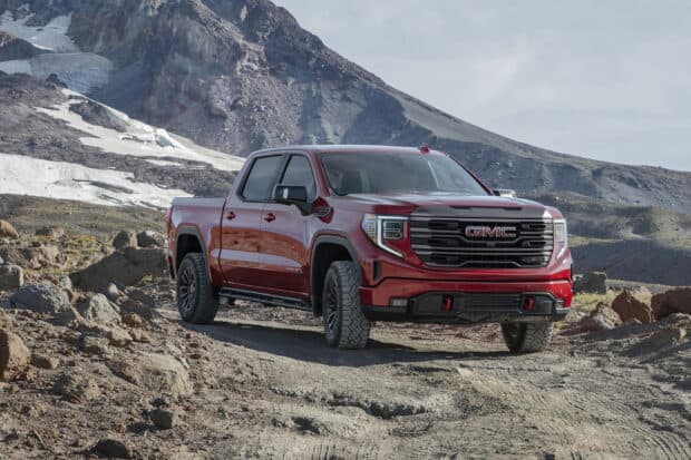 A red Gmc Sierra truck drives on rugged mountain terrain with rocky paths, HD Desktop Wallpaper