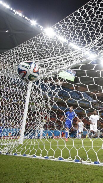 A football hits the net as players watch during a match, HD Phone Wallpaper