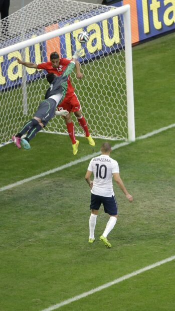 A goalkeeper jumps to save a goal sports moment during a soccer match, HD Phone Wallpaper
