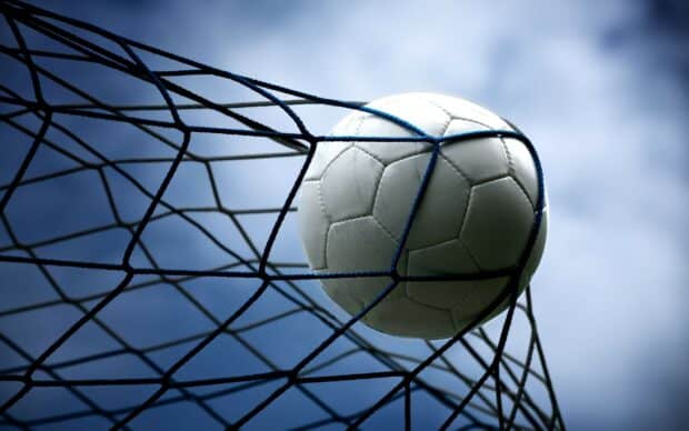 A soccer ball is captured inside the net during a goal in a sports match, 2K Desktop Wallpaper