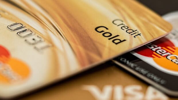 A close up of a gold credit card focusing on Mastercard logos and numbers, HD Desktop Wallpaper