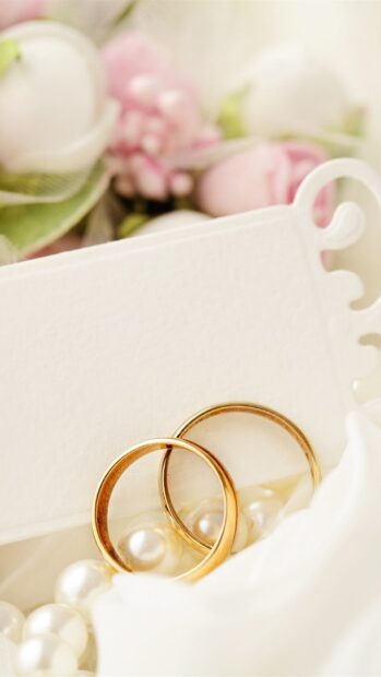 Two gold wedding rings resting on pearls with delicate flowers in the background, HD Mobile Wallpaper