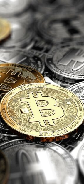 A golden Bitcoin shines among silver coins representing digital currency investments, HD Mobile Wallpaper