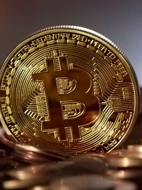 A close up of a golden Bitcoin token showing intricate details on its surface, 2K Mobile Wallpaper